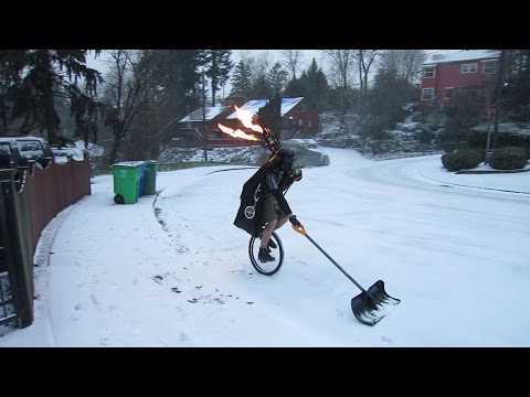 Man Shoveling Snow on a Unicycle Dressed as Darth Vader While Playing Flaming Bagpipes