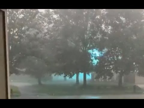 Glowing Blue Ionized Energy Arching Across a Power Line During a Storm